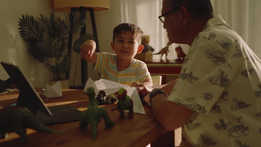 Grandfather sitting with his little grandson at the table