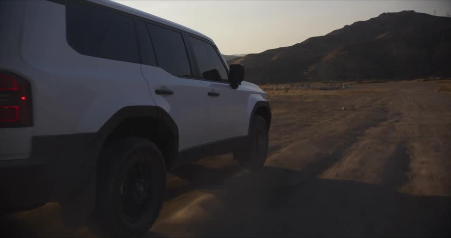 White sports car traveling along a track surrounded by mountains