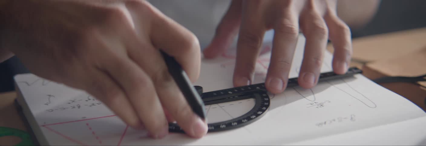 A student is using a protractor and writing in a notebook