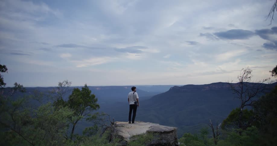 Standing on a flat rock platform on top of a mountain and admiring the canyon