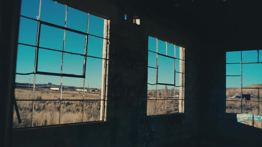 Windows of an abandoned building lookout on a busy rural highway