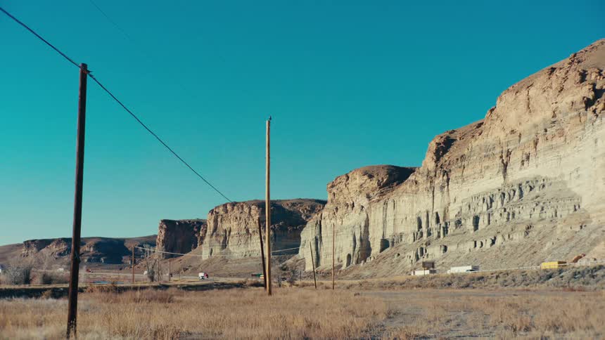 Vehicle traffic next to mountain ruins