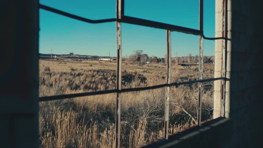 View through a barred window of a highway with vehicle traffic