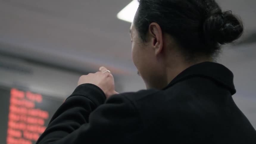 Airport employees talk while looking at a monitor