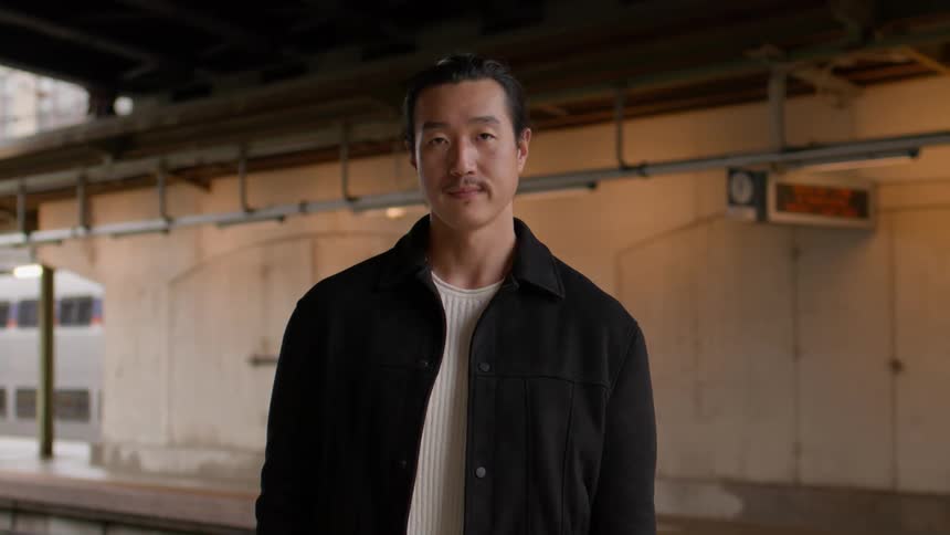 Man in a black jacket at a subway station
