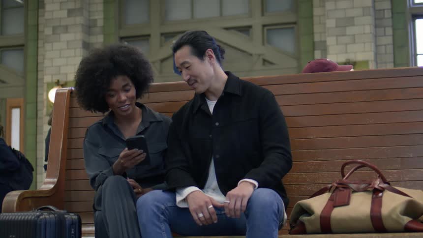 A man and woman talk and look at a cell phone