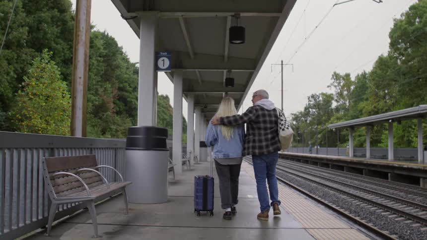 A clip of a couple walking beside the railway