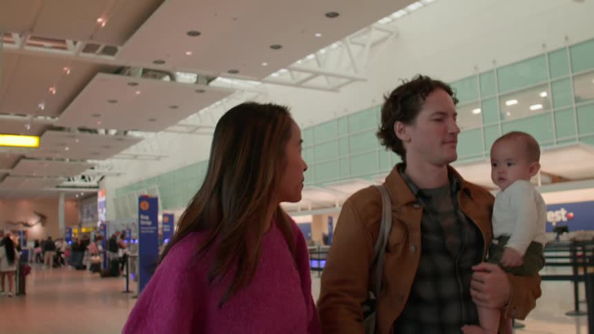 A family walk through the airport terminal together