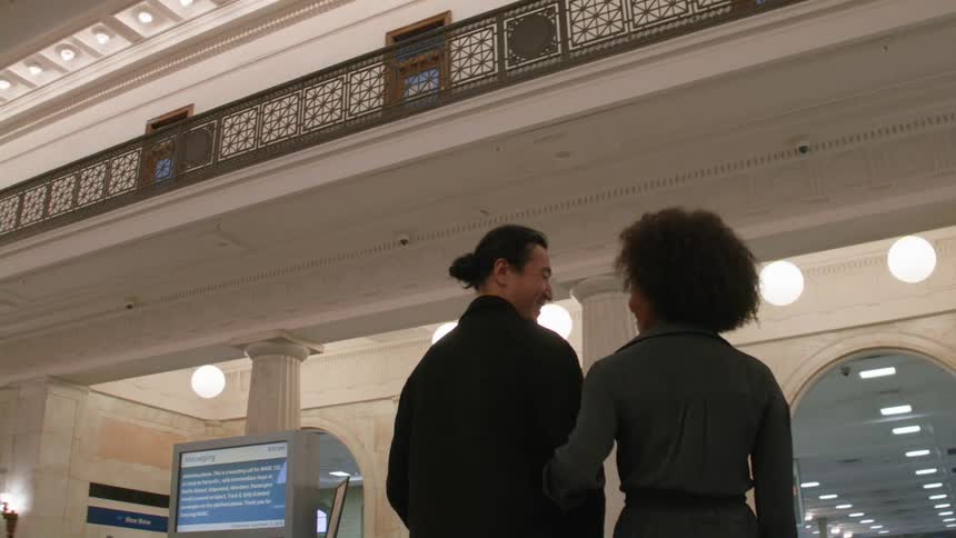 Couple with arms together walking through a subway station