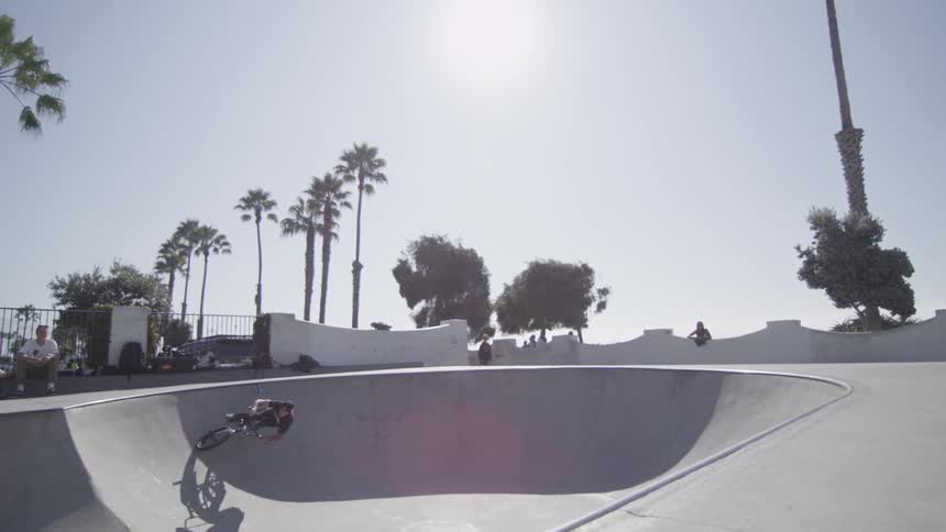 Man doing jumps on his bike in a park on a sunny day