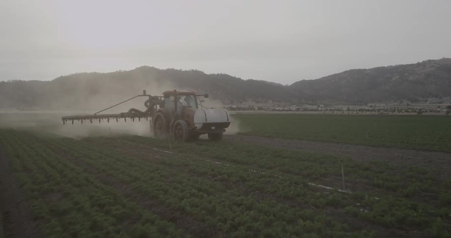 A chemical is being sprayed on a farmer's crop