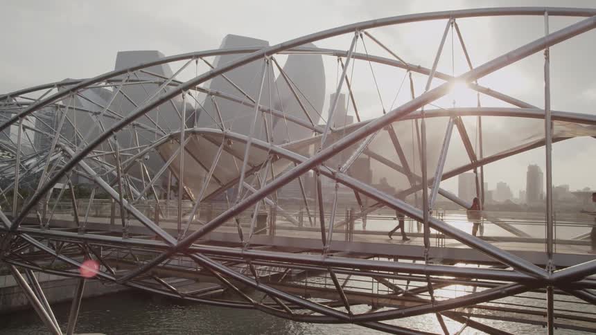 People cross an elaborate city bridge
