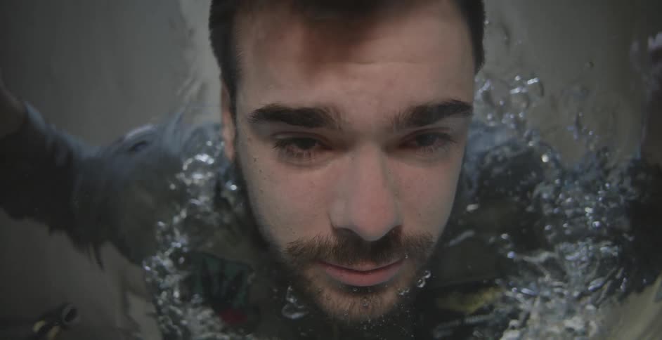 A man opens his eyes and breathes underwater