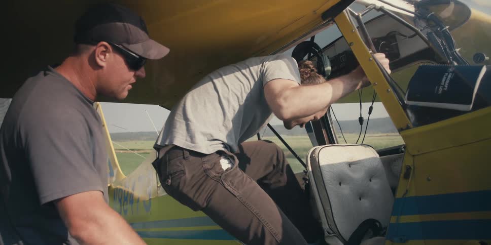 Passenger entering a small plane next to the pilot