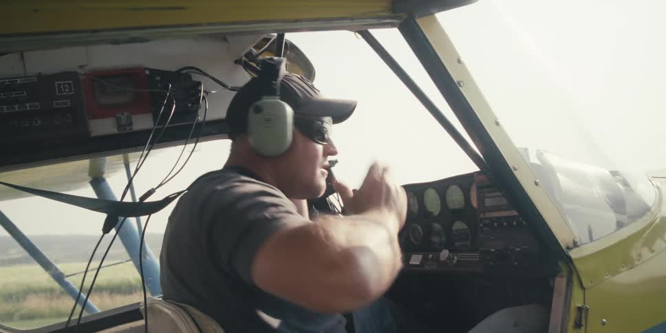 Pilot puts on headphones in a small plane before takeoff
