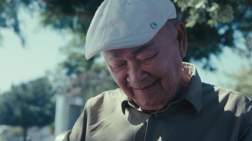 A man is looking down and smiling