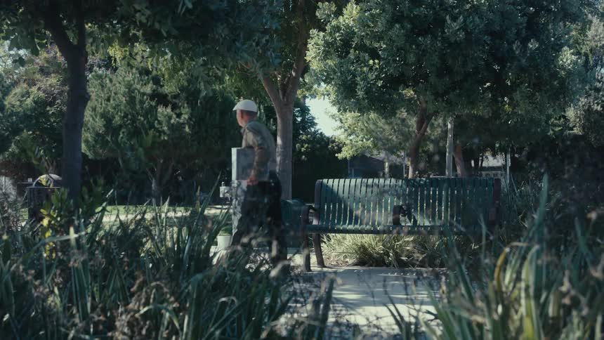 A man gets up from the bench and walks away