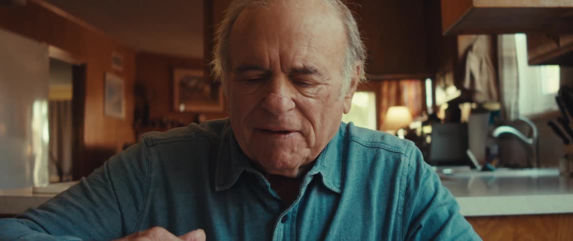 A man smiles as he finishes wrapping a gift