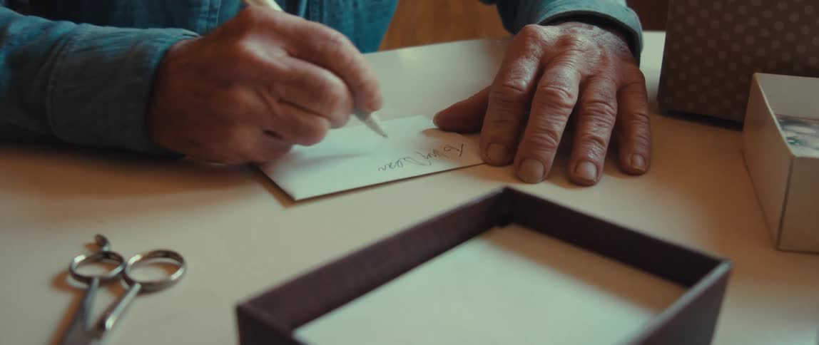 Close up of the hands of an elderly man writing a note