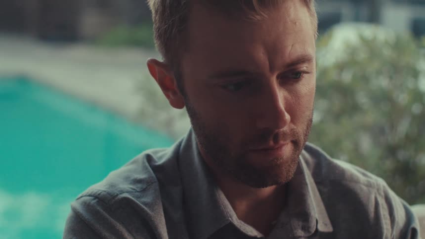 Portrait of a man talking and a swimming pool in the background