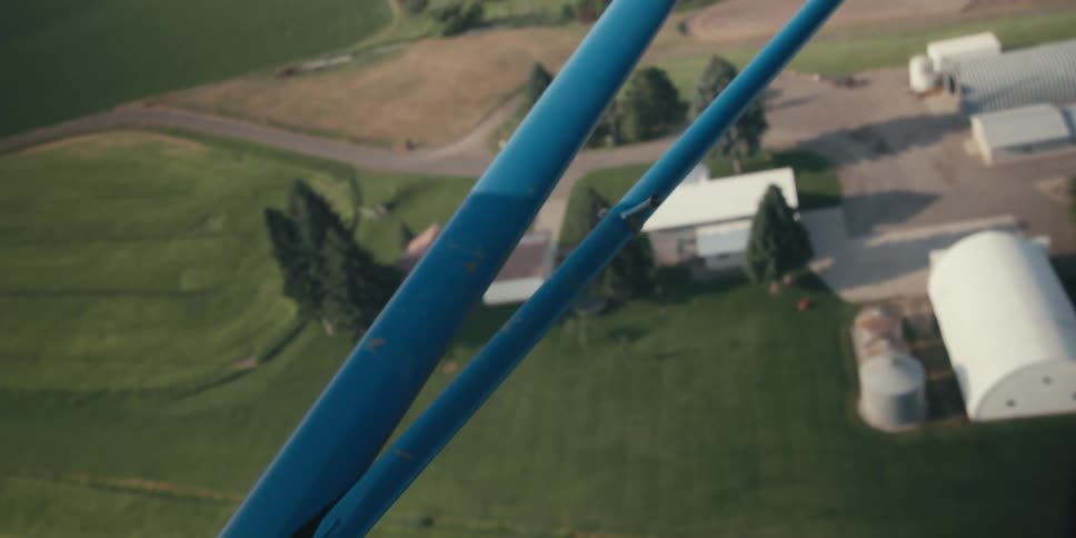 A plane flies over the farm