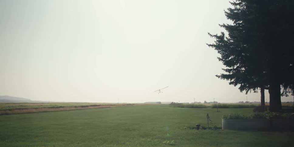 A plane races on the grass runway and takes off