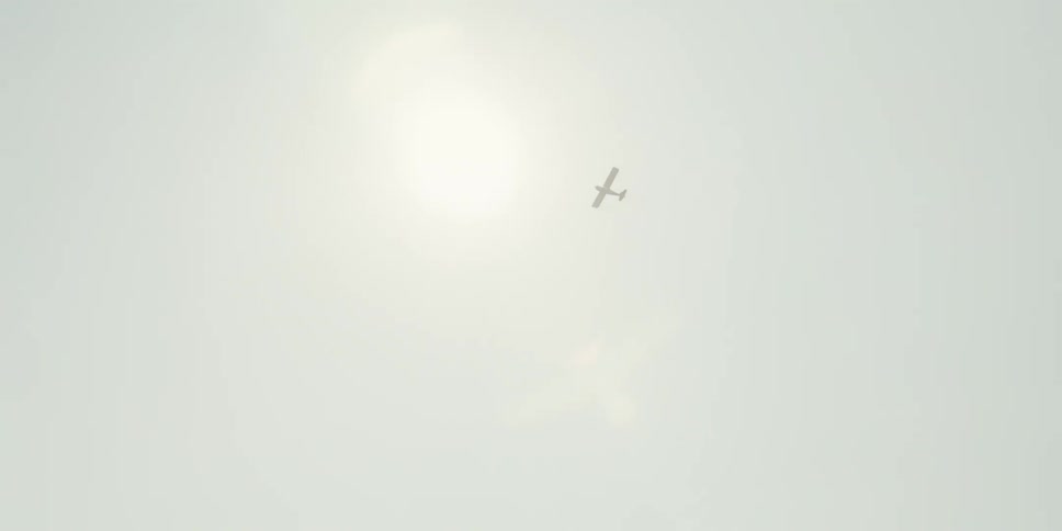 Airplane high in the sky is flying on a clear and sunny day