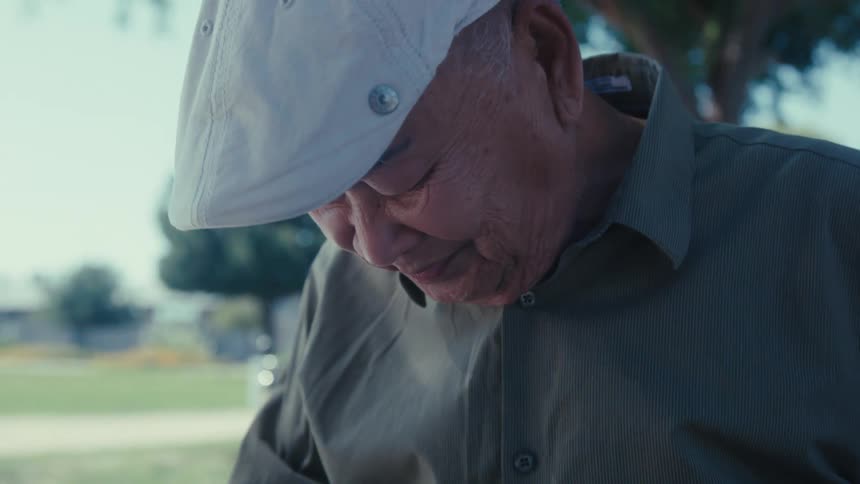 Elderly man sitting looking at a photo album