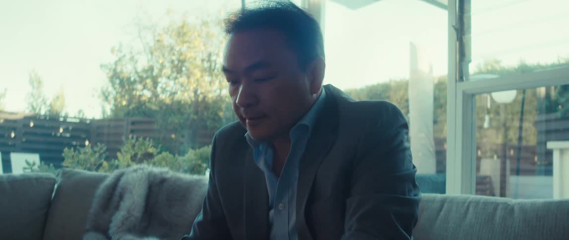 A man in a business suit working on a laptop at home