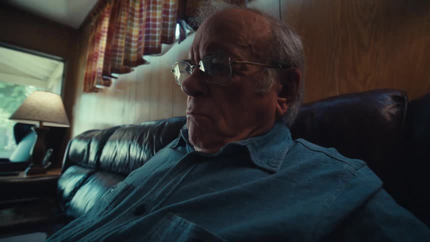 Man wearing glasses and sitting on a couch in his home