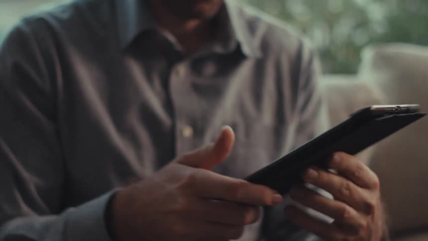 A man is typing on his tablet