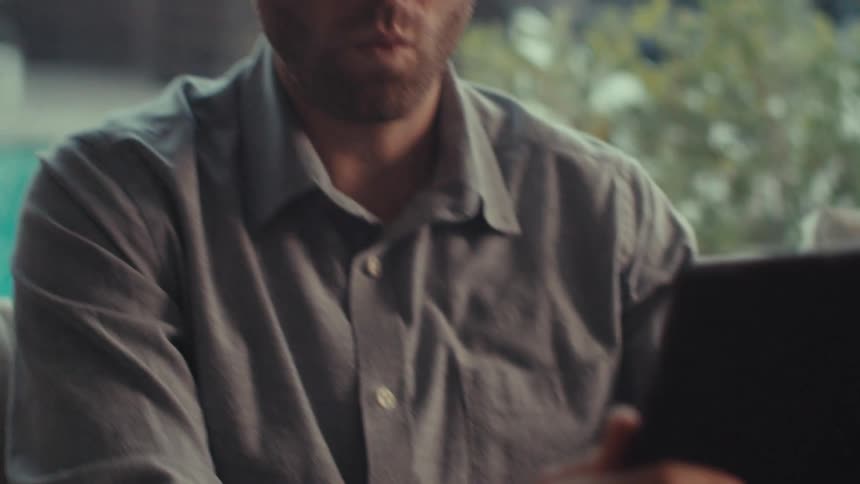 Man holds a tablet with both hands and talks to it