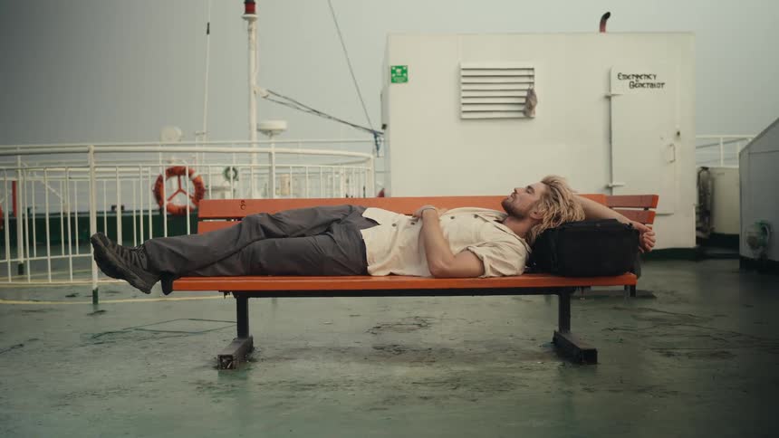 A clip of a man laying on a bench