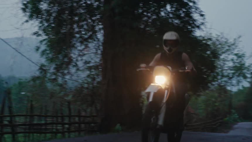 A person driving a motorcycle on a countryside road