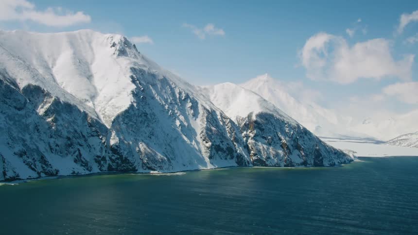 A large snowy mountain as seen from a ship