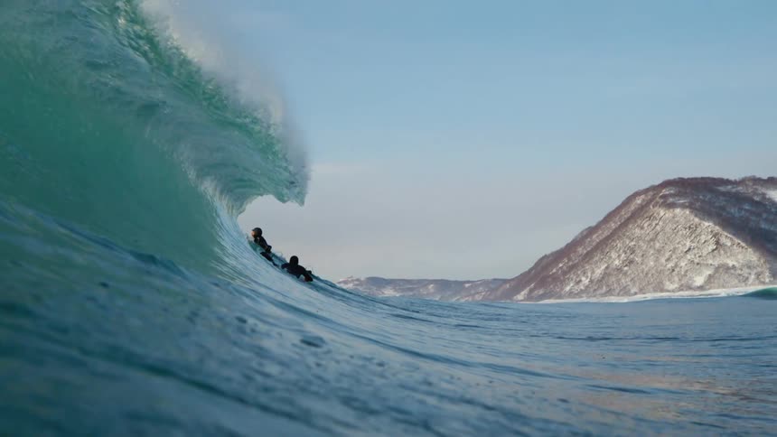 Two surfers riding a big wave in the ocean
