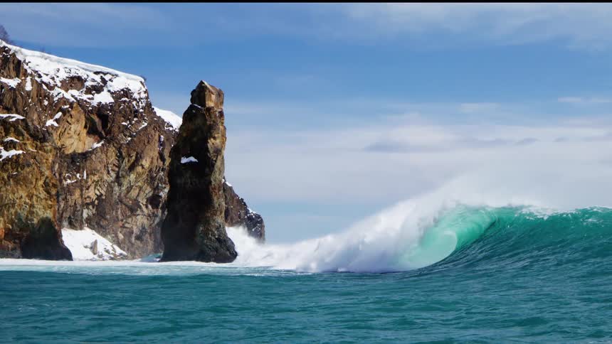 The tide from the ocean is moving towards the rock formation
