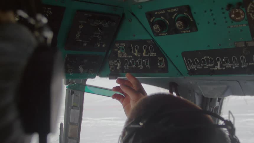 Pilot in the cockpit configuring the buttons on the top