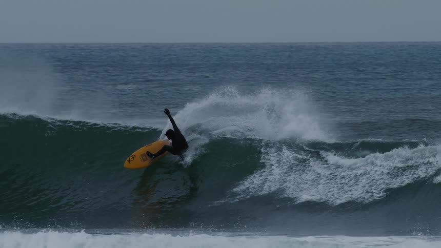 Person is surfing by themselves on large waves in the ocean sea