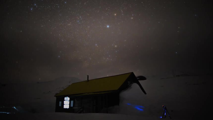 Cabin in the snow against a starry sky