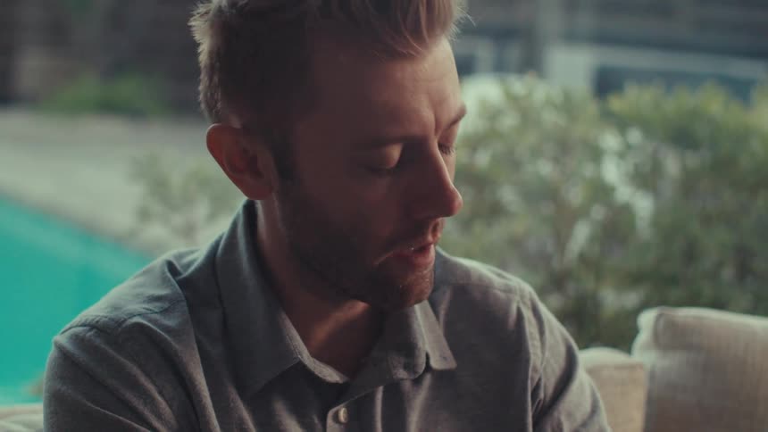 Man nods his head and talks while looking down ahead of him