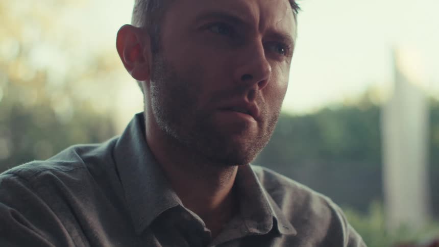 A man stops to think as he uses a tablet