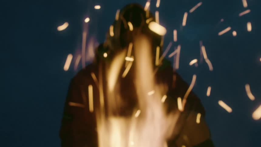 In the middle of winter a man is warming up by a fire