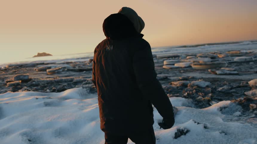 Person in winter jacket walking in snowy area