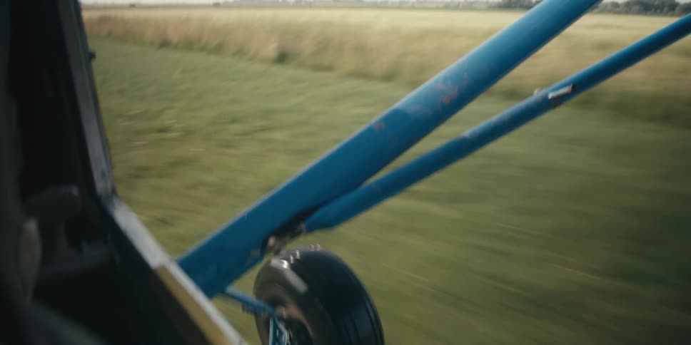 A small airplanes wheel bumps along the ground causing the wing to also bounce