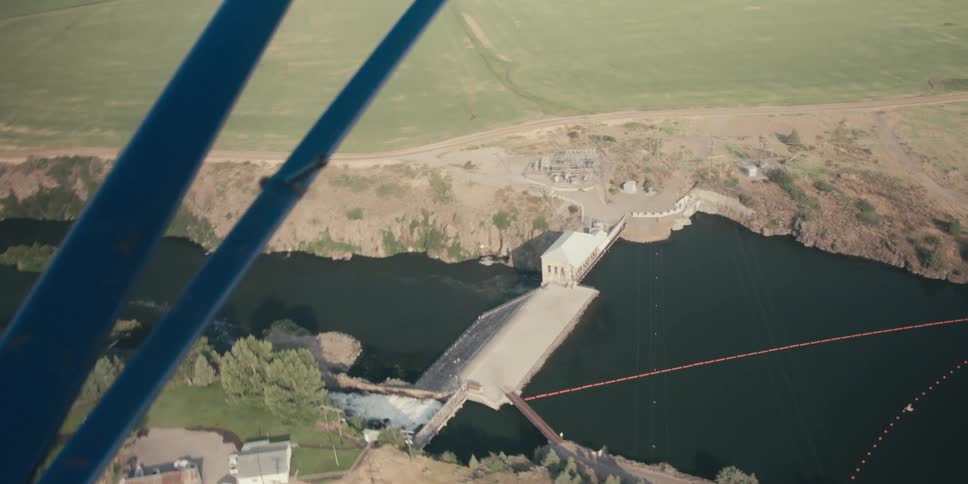 The view of a river dam from inside an airplane