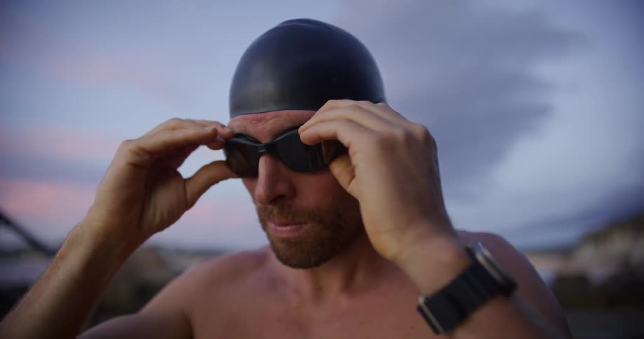 The swimmer puts on his goggles