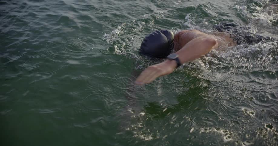 Slow motion of a man swimming through open water