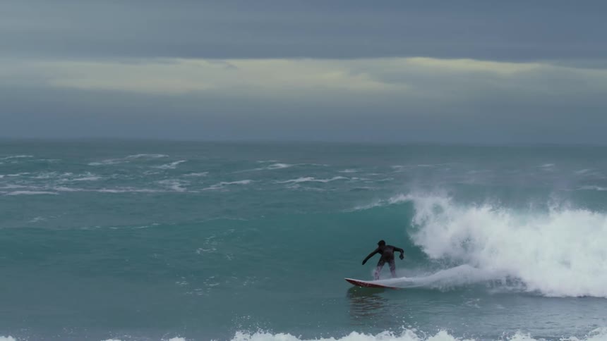 Person surfing waves at a beach in winter