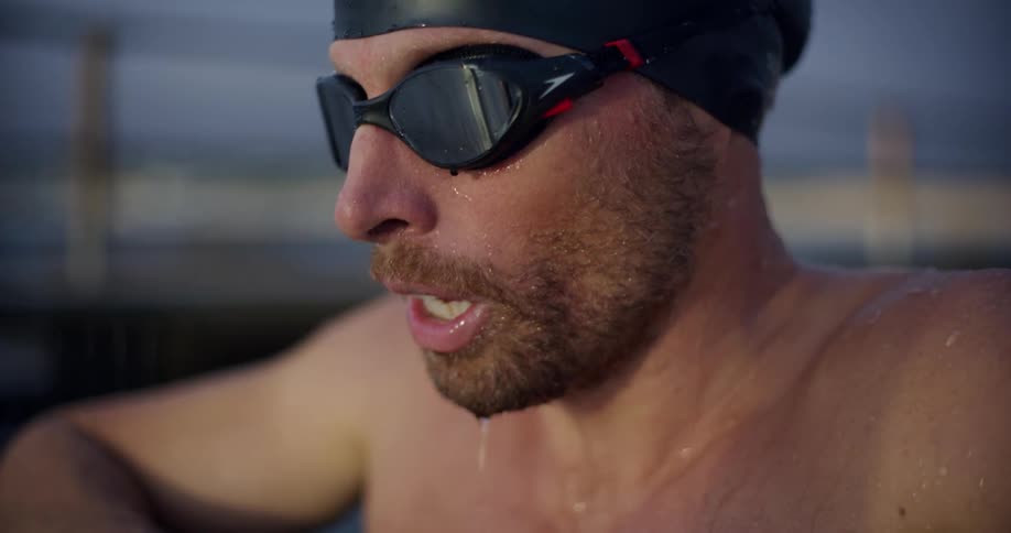 Portrait of a swimmer coming out of the water and taking a deep breath catching his breath